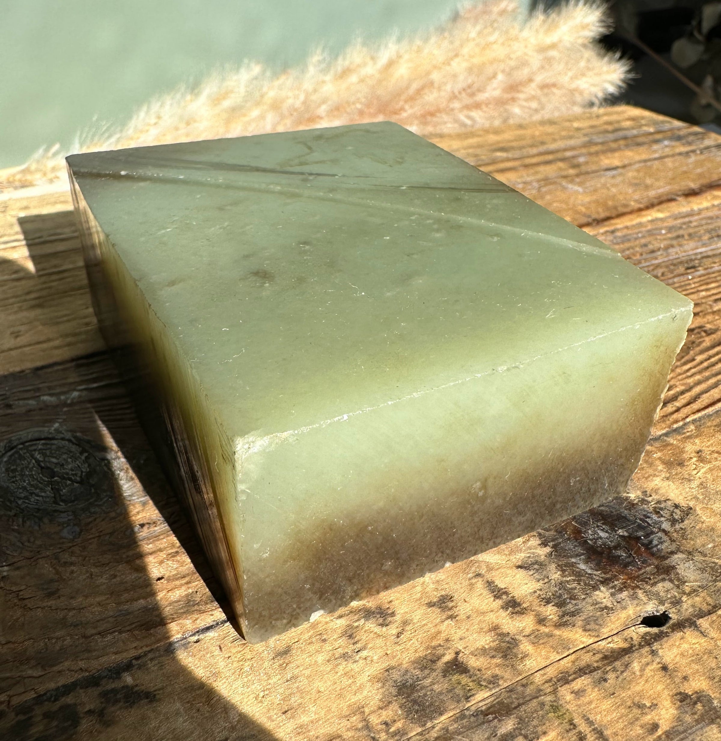 Siberian Jade Rough block on a weathered wooden surface