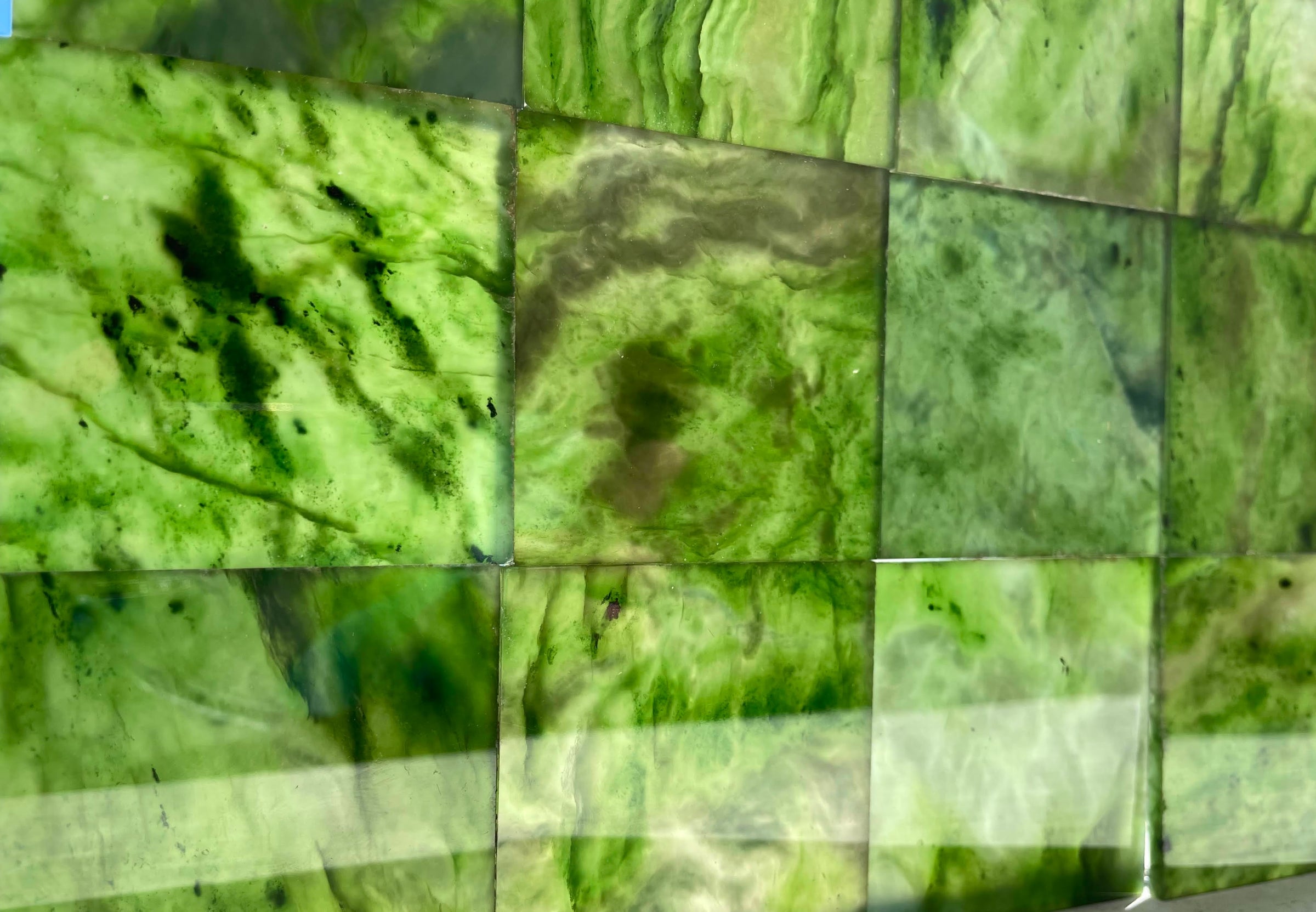 Close up of a mosaic made from green jade tiles in varying shades