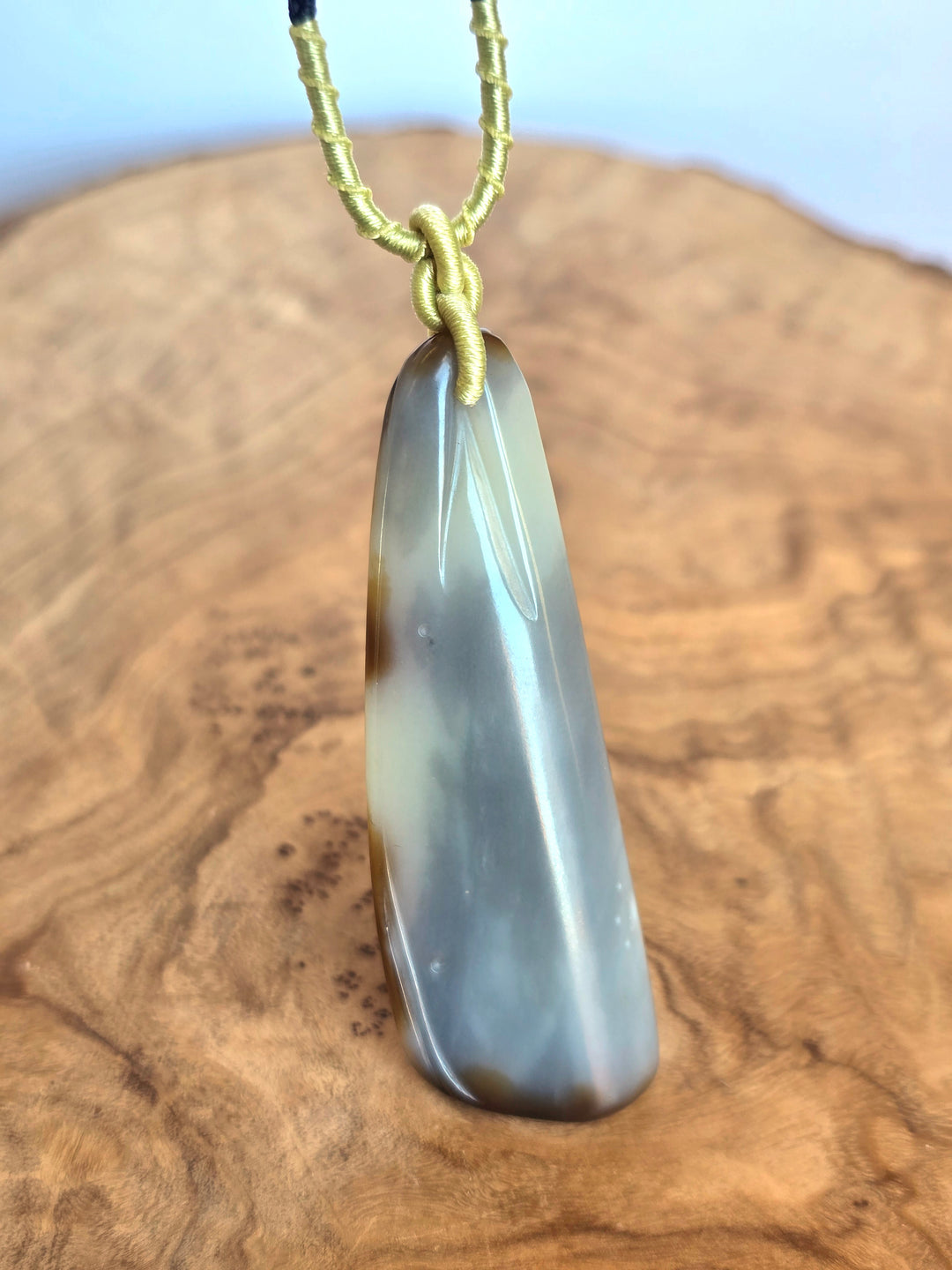 65mm Loulan jade nephrite pendant in a smooth teardrop shape suspended from a pale yellow green cord