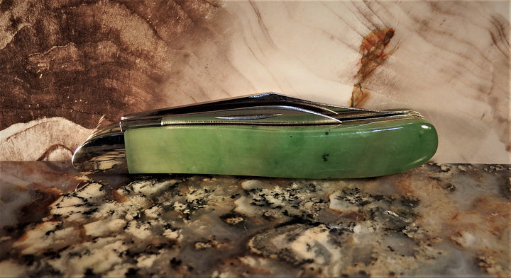 Ogden Jade Knife by Michael Hoover with jade handle and folded silver blades resting on a granite countertop.