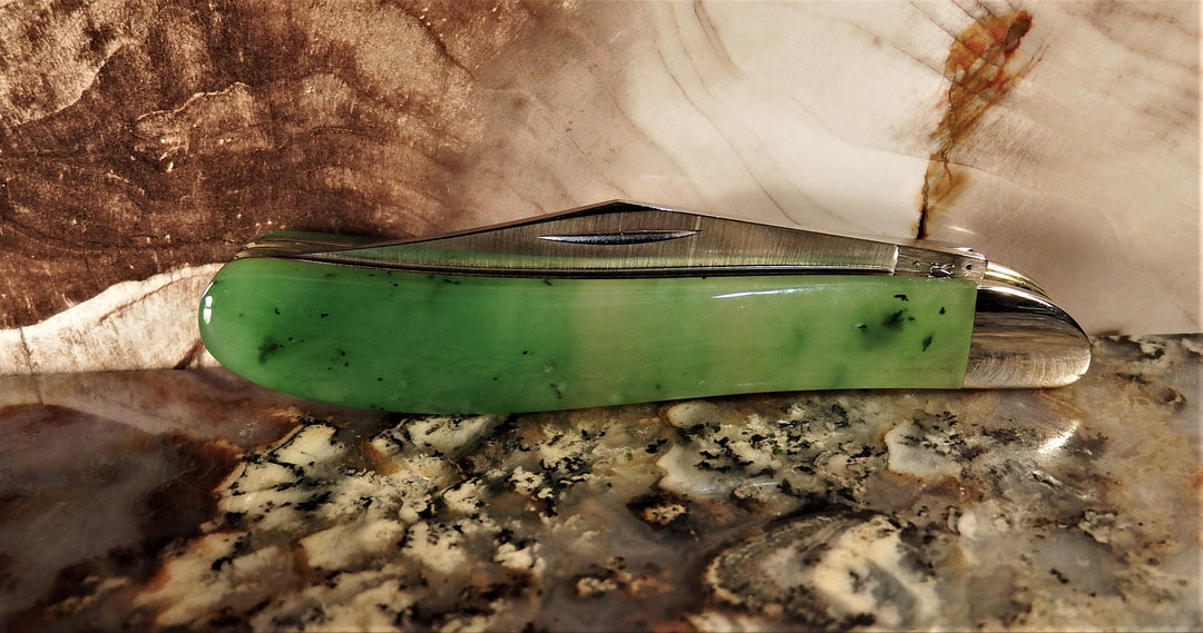 Ogden Jade Knife by Michael Hoover featuring jade handle and blades fanned along the spine on a marble surface.