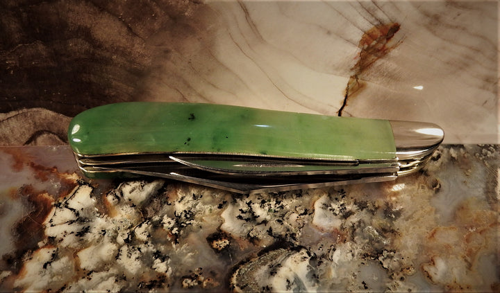 Ogden Jade Knife by Michael Hoover jade handle with blades spread along the side on a granite countertop.