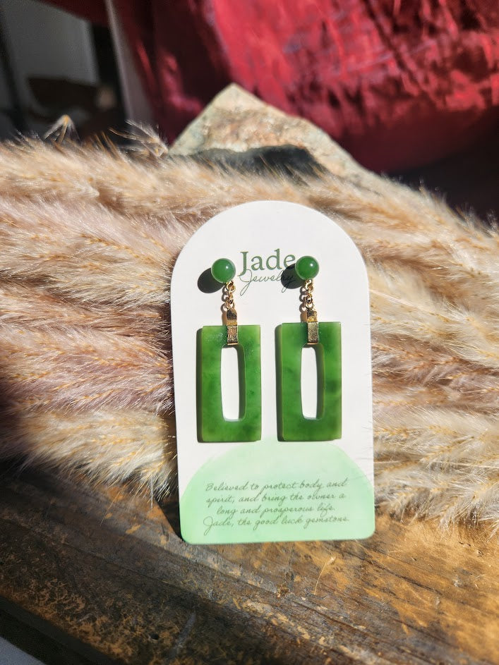 Vintage Jade rectangle drop earrings on a white display card set on a fuzzy fur surface.