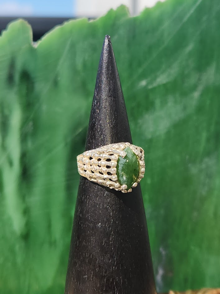 Vintage Jade Ring with marquise green jade center and an open lattice silver band shown on a black display cone.