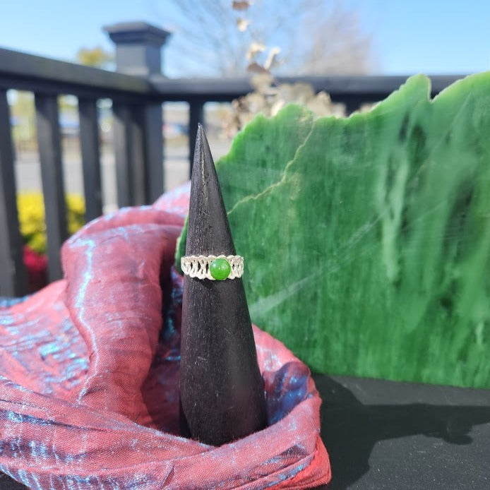 Silver Jade Ring with a vivid green jade cabochon on an ornate silver band displayed on a black ring cone