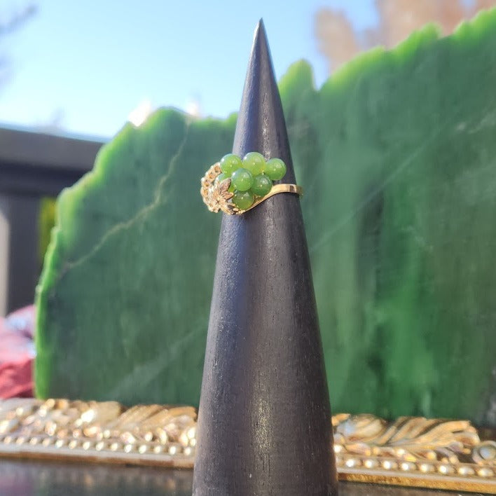 Vintage Jade grape ring with green bead cluster and gold leaf setting displayed on a ring cone.