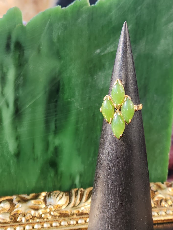 Vintage Jade Ring with five green marquise jade stones arranged in a gold floral setting on a display cone