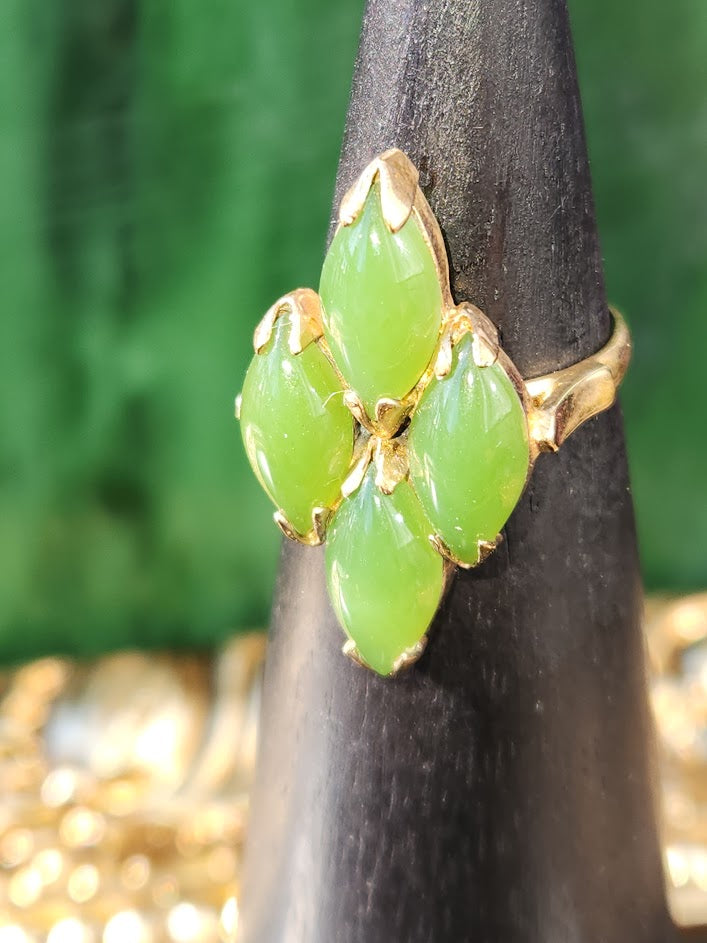 Vintage jade ring with five marquise green stones in a gold setting on a dark display stand
