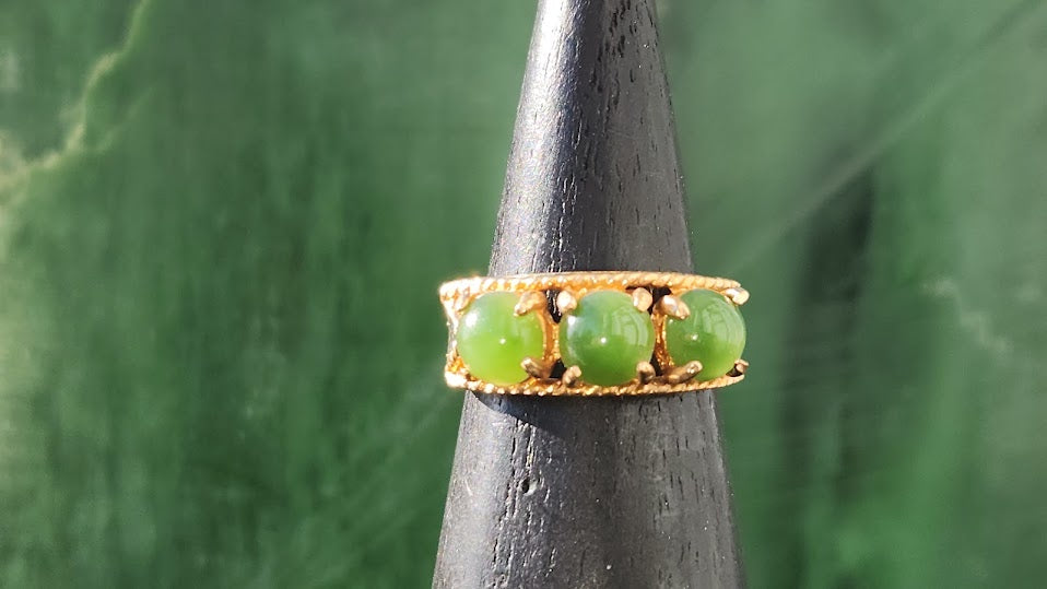 Vintage Jade Ring with three green beads on a textured gold band displayed on a cone
