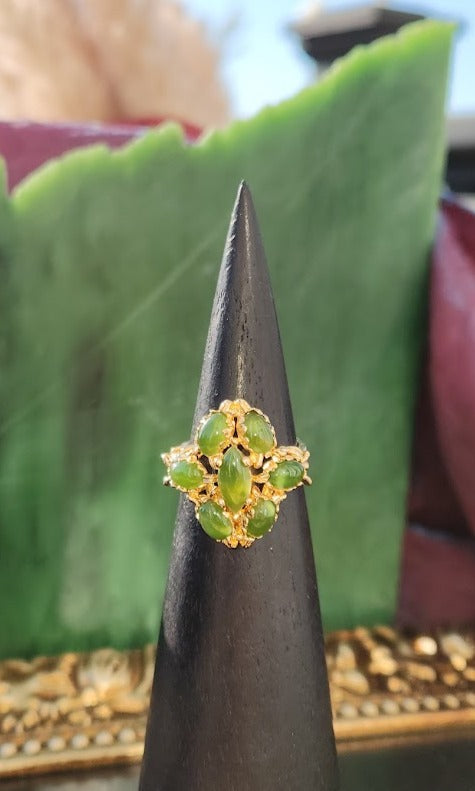 Vintage Jade Ring with multiple green jade cabochons in a gold ornate setting atop a black cone display.