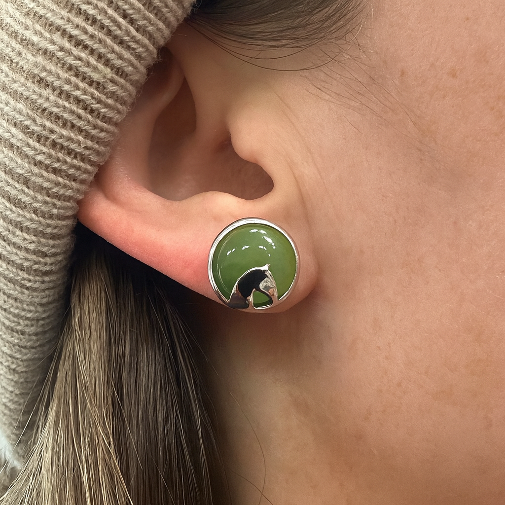 Circular jade green stud earring with a silver horse silhouette worn on the earlobe