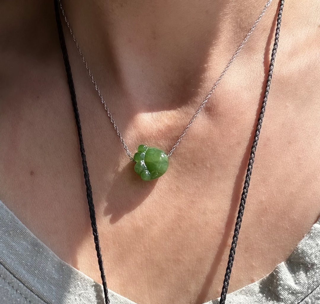 Jade cat paw pendant on a silver chain worn at the collarbone