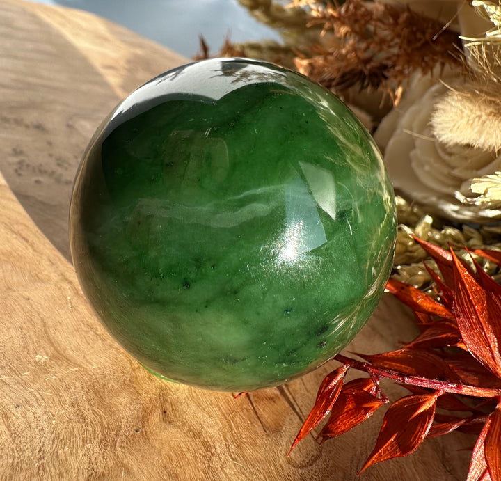 Polished Canadian Jade Sphere 50mm with rich green color and subtle flecks