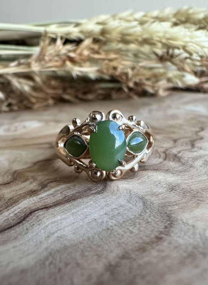 Vintage Jade Mask Ring with a central oval green jade cabochon and two smaller green stones in an ornate silver setting