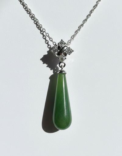 Necklace with a green teardrop pendant on a white background