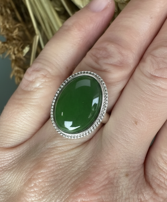 Canadian Jade Silver Ring shown on finger with a bright green oval cabochon and rope border.