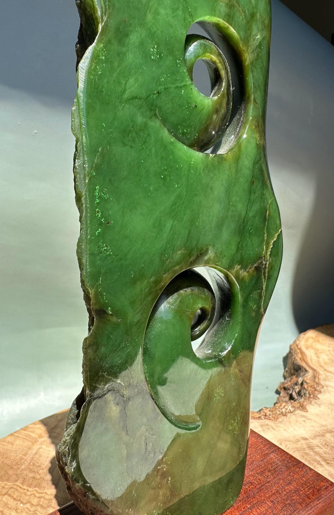 Side view of the Canadian Jade Double Koru Sculpture showing two glossy green jade spiral carvings