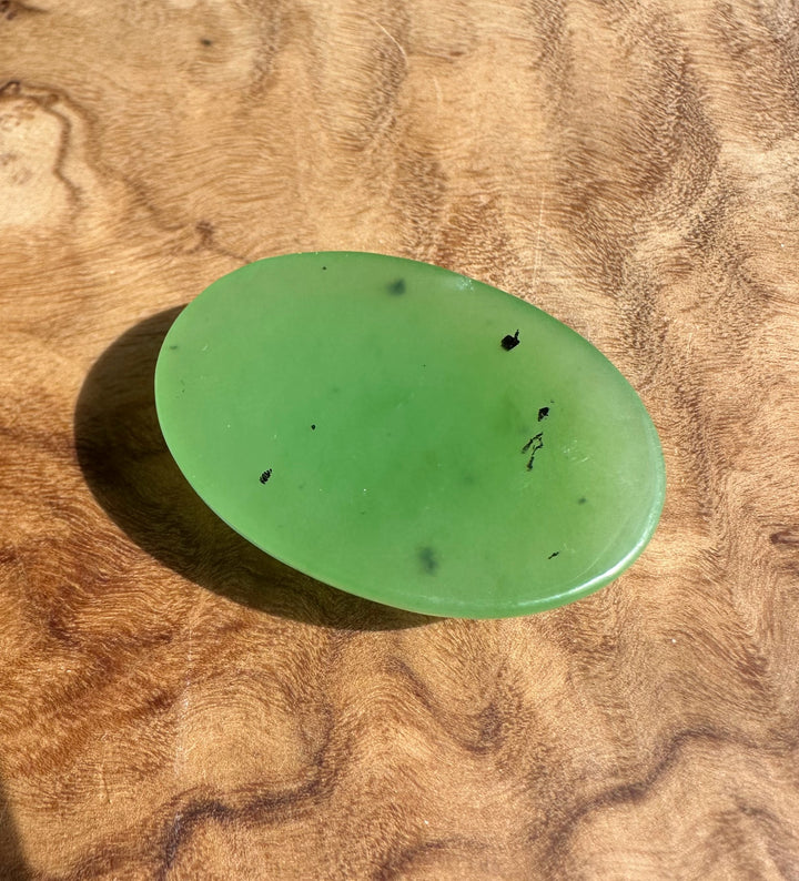 Oval apple green cabochon 30x22mm on a wood surface