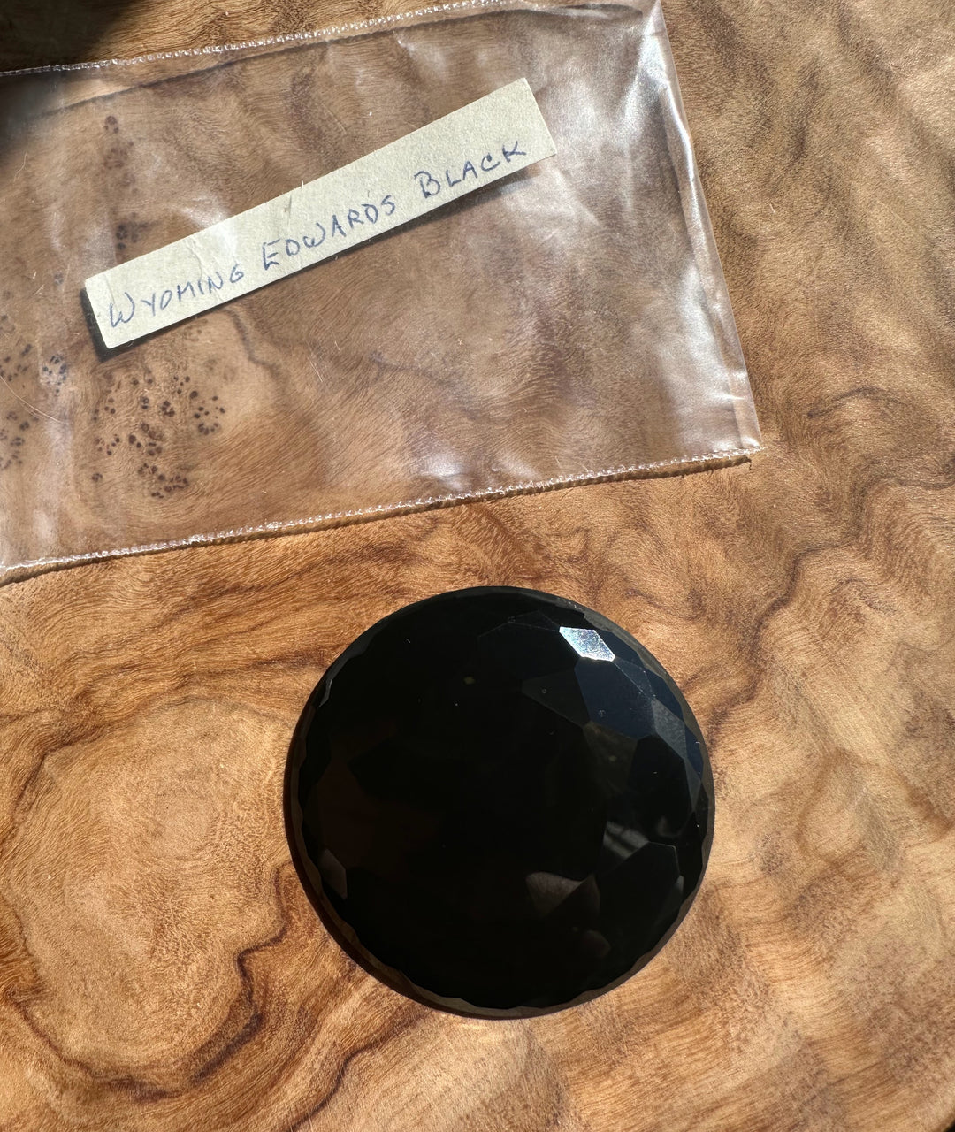 Black stone on a wooden surface with a label reading &