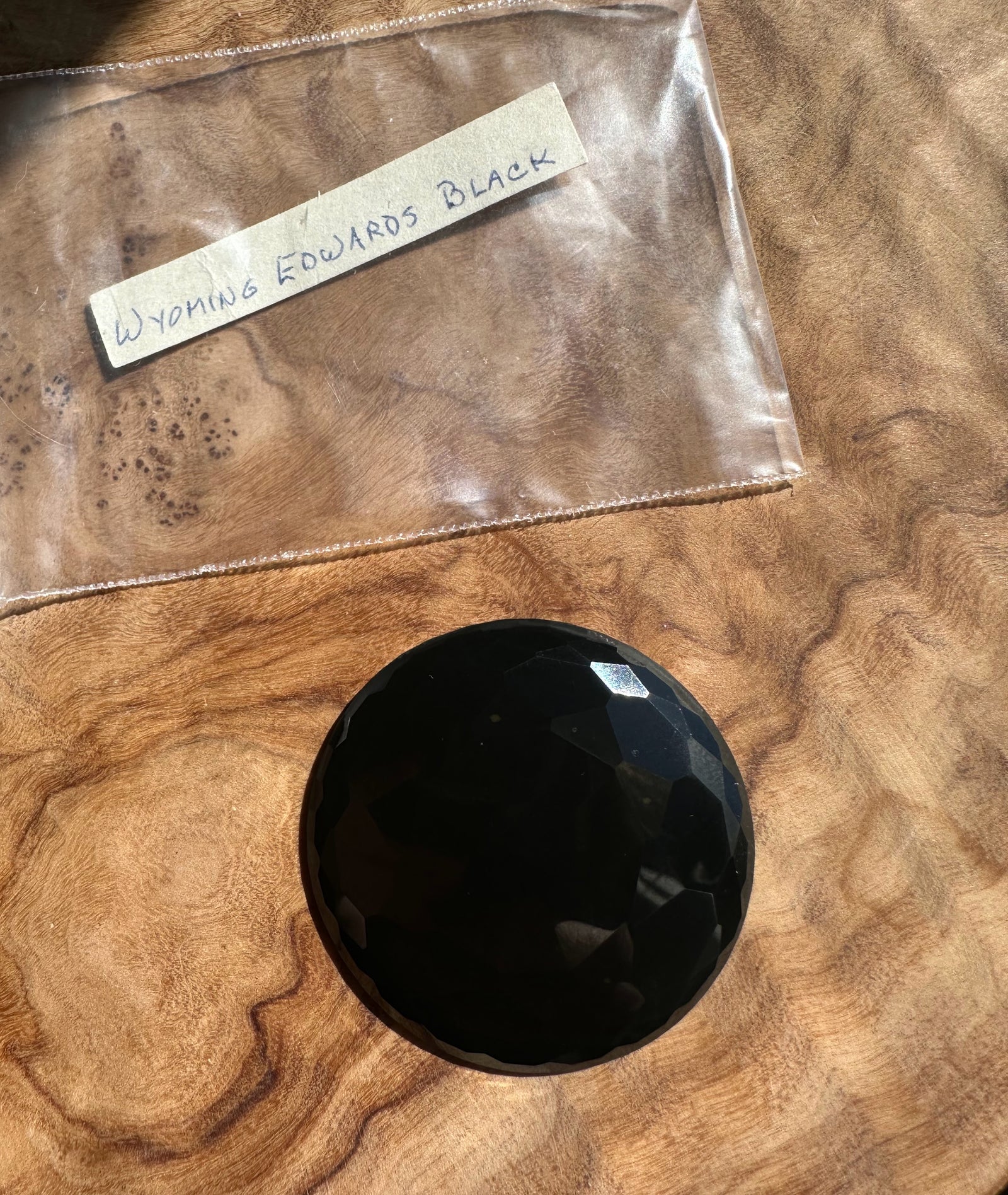 Black stone on a wooden surface with a label reading 'Wyoming Edwards Black'.