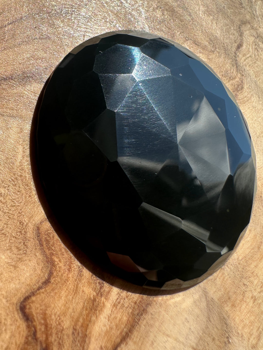 Faceted black jade on a wooden surface
