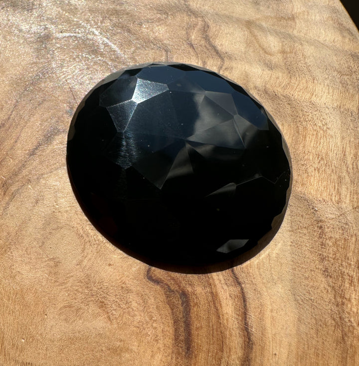 Faceted black jade on a wooden surface