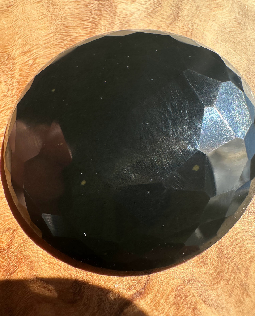 Faceted black jade on a wooden surface