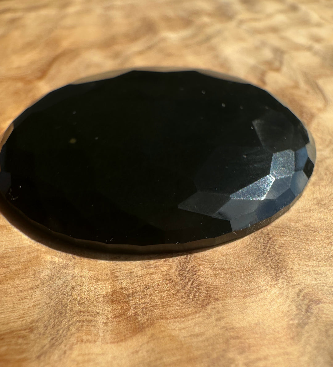 Faceted black jade on a wooden surface