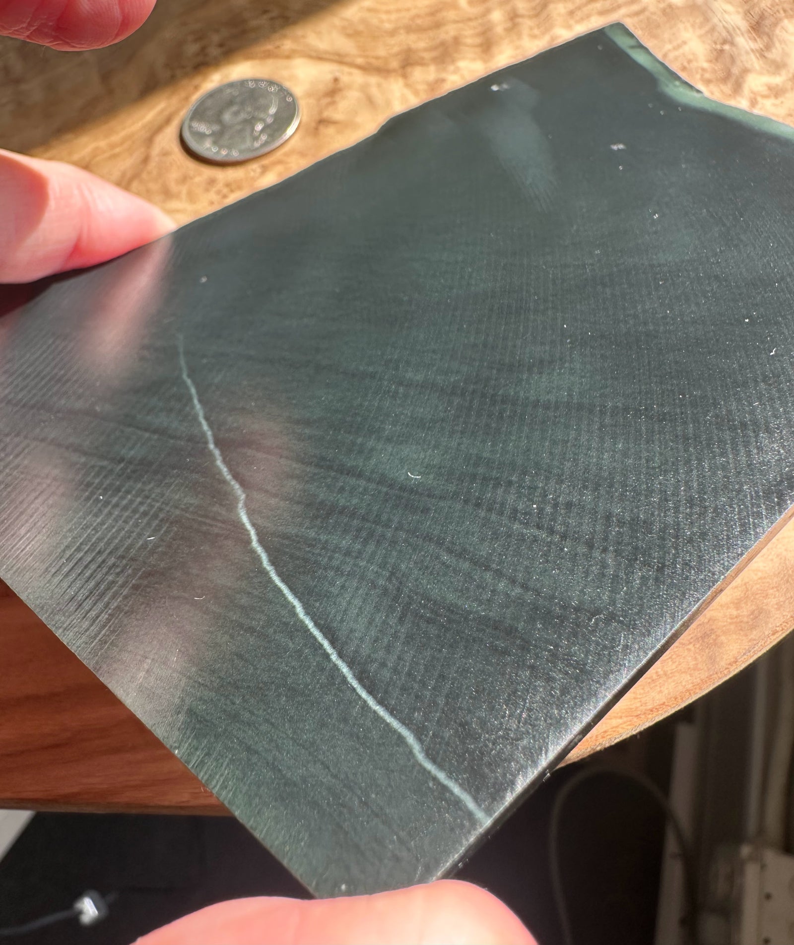 Black jade held by a hand on a wooden surface