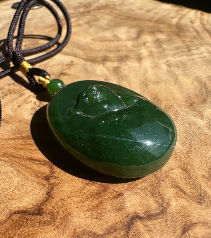 Green jade pendant on a wooden surface