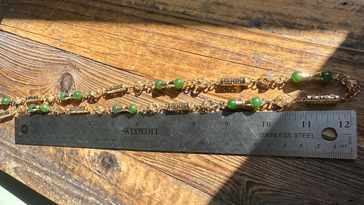 Close up of Vintage Jade Necklace 30 inch with green beads and gold links beside a ruler for scale.