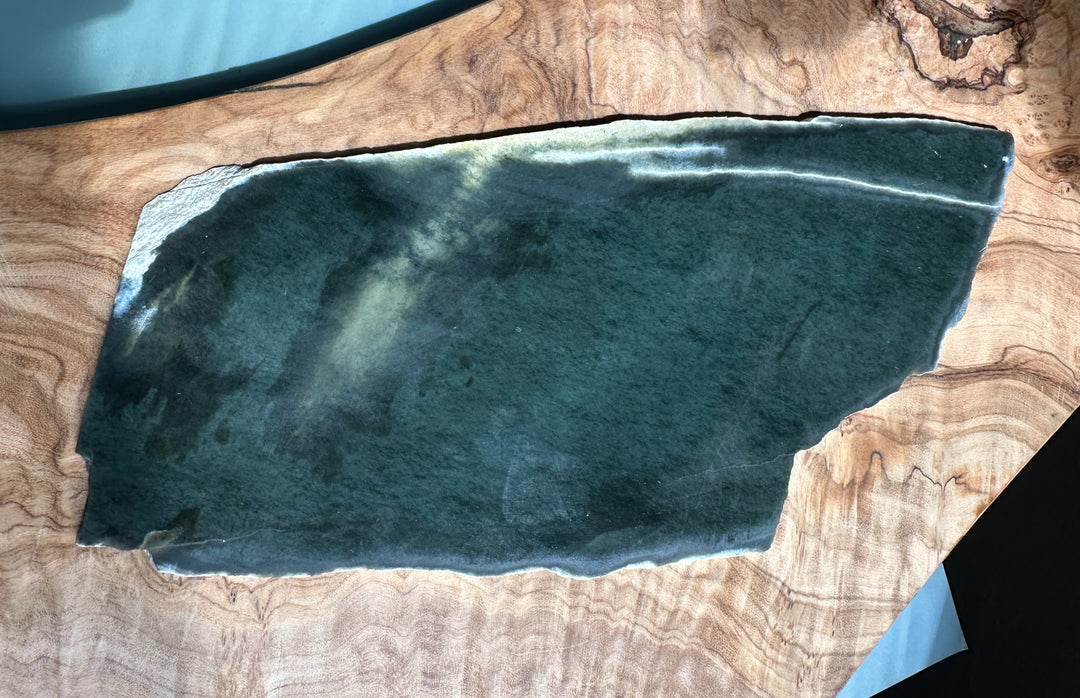 Wyoming Slab 230g dark teal blue-green slab with a light edge on a wooden surface