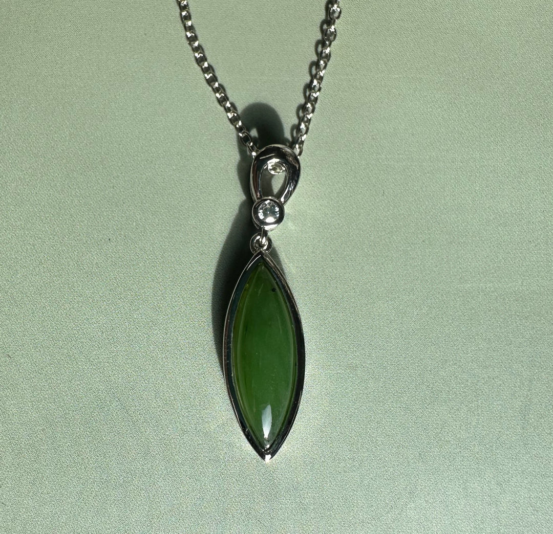 Green jade pendant with a marquise cabochon set in a silver bezel and a small round CZ above on a silver chain