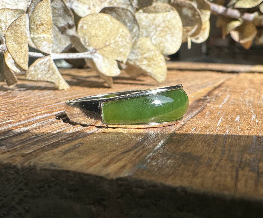 Canadian Jade Ring 3399 side view showing green jade cabochon set in a silver bezel on a wood plank