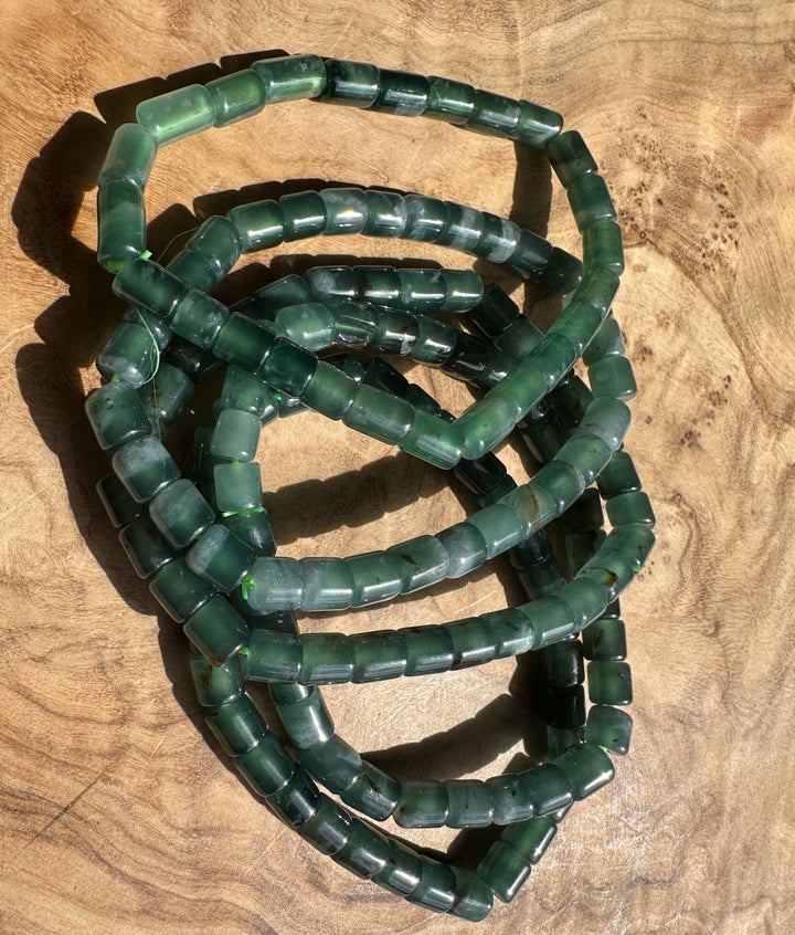 Blue Green beaded bracelets stacked on a wooden surface