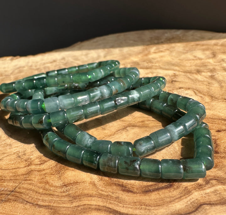Green jadeite beaded bracelet on a wooden surface