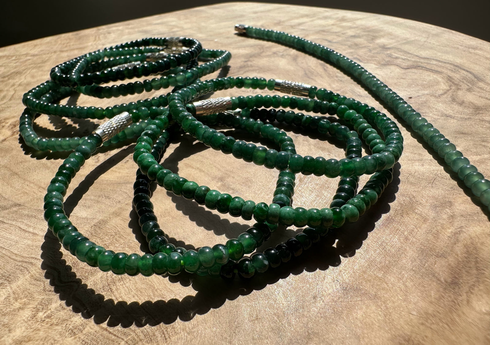 Green Blue beaded bracelets on a wooden surface