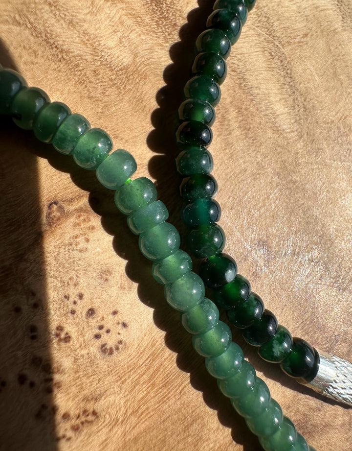 Green and blue beaded bracelet on a wooden surface