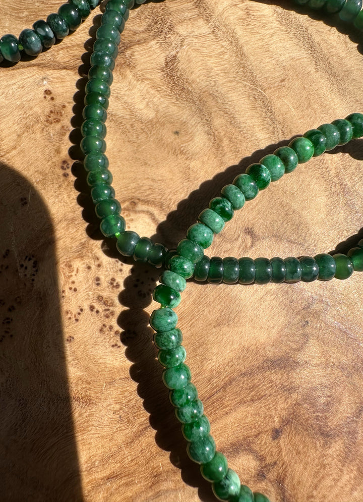 Green beaded necklace on a wooden surface