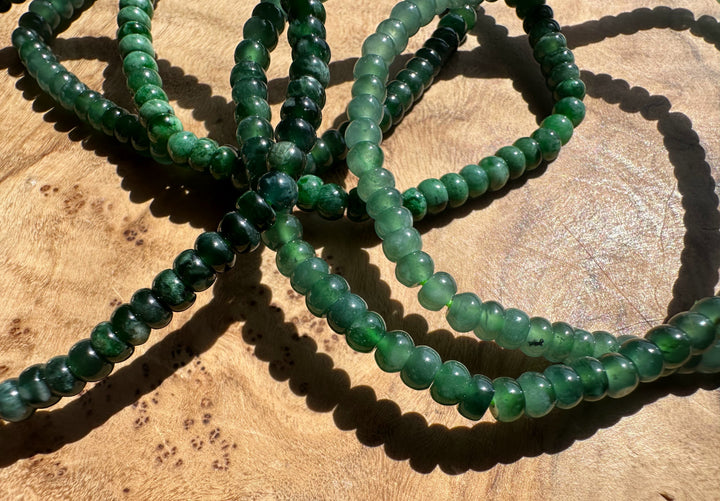 Green beaded bracelets on a wooden surface
