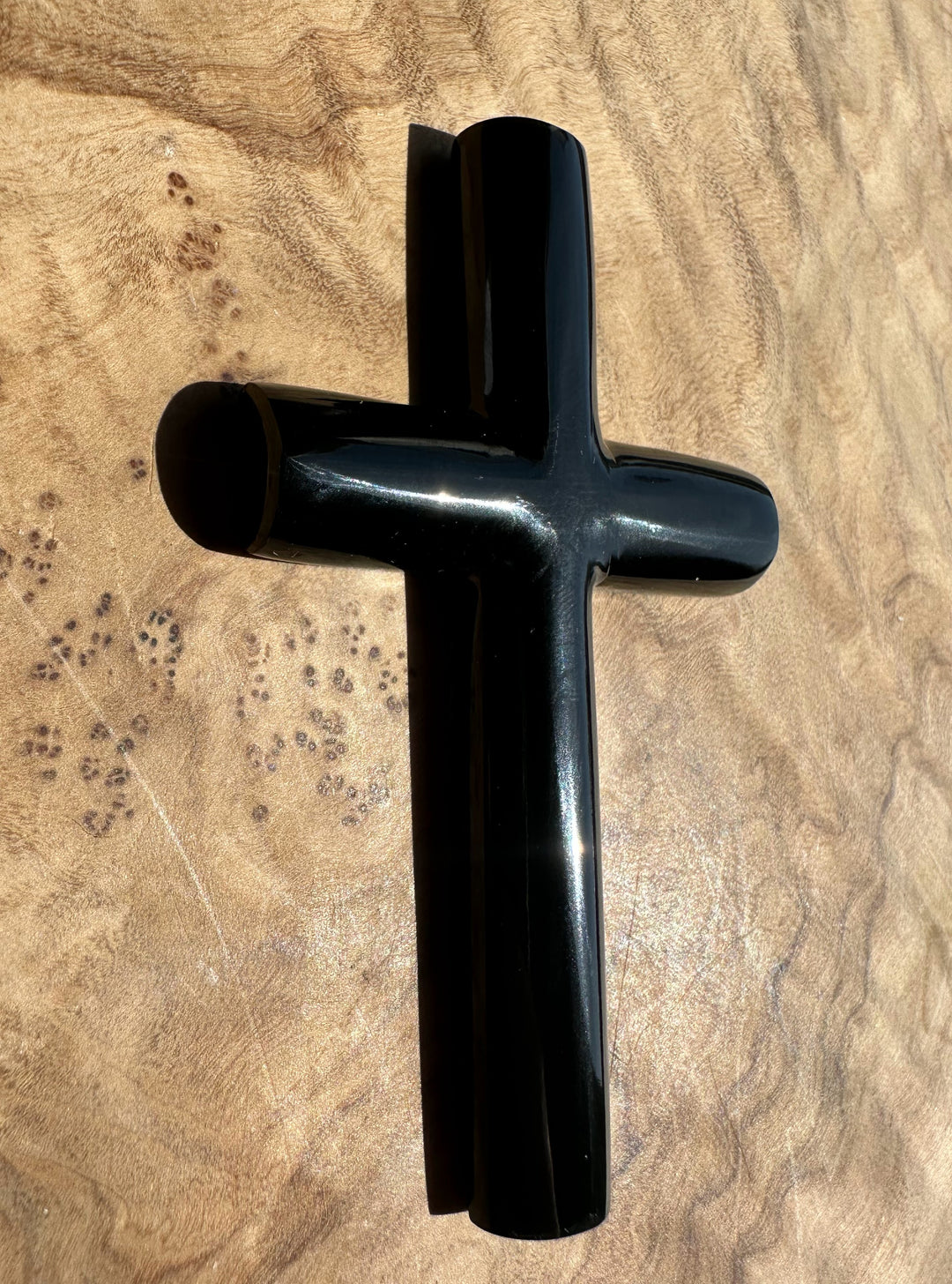 Black cross-shaped object on a textured beige surface