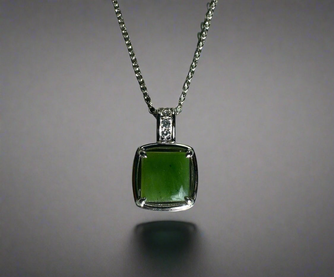 Canadian jade pendant featuring a square green jade stone in a silver setting with CZ-studded bail on a silver chain