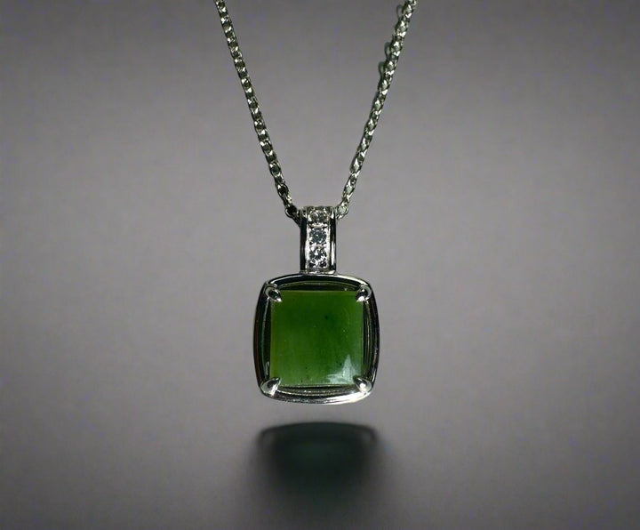 Canadian jade pendant featuring a square green jade stone in a silver setting with CZ-studded bail on a silver chain