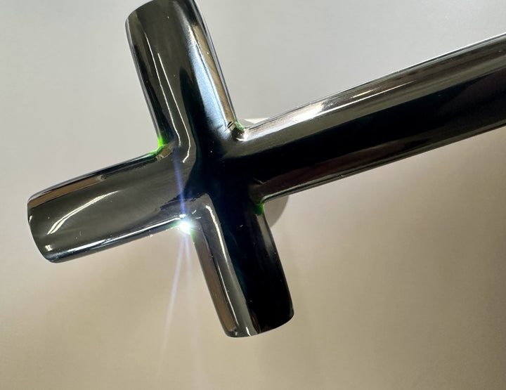 Close-up of a jade cross on a neutral background