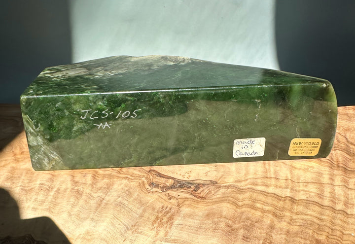 Green jade candle holder specimen with a glossy surface and chalk markings on the side.