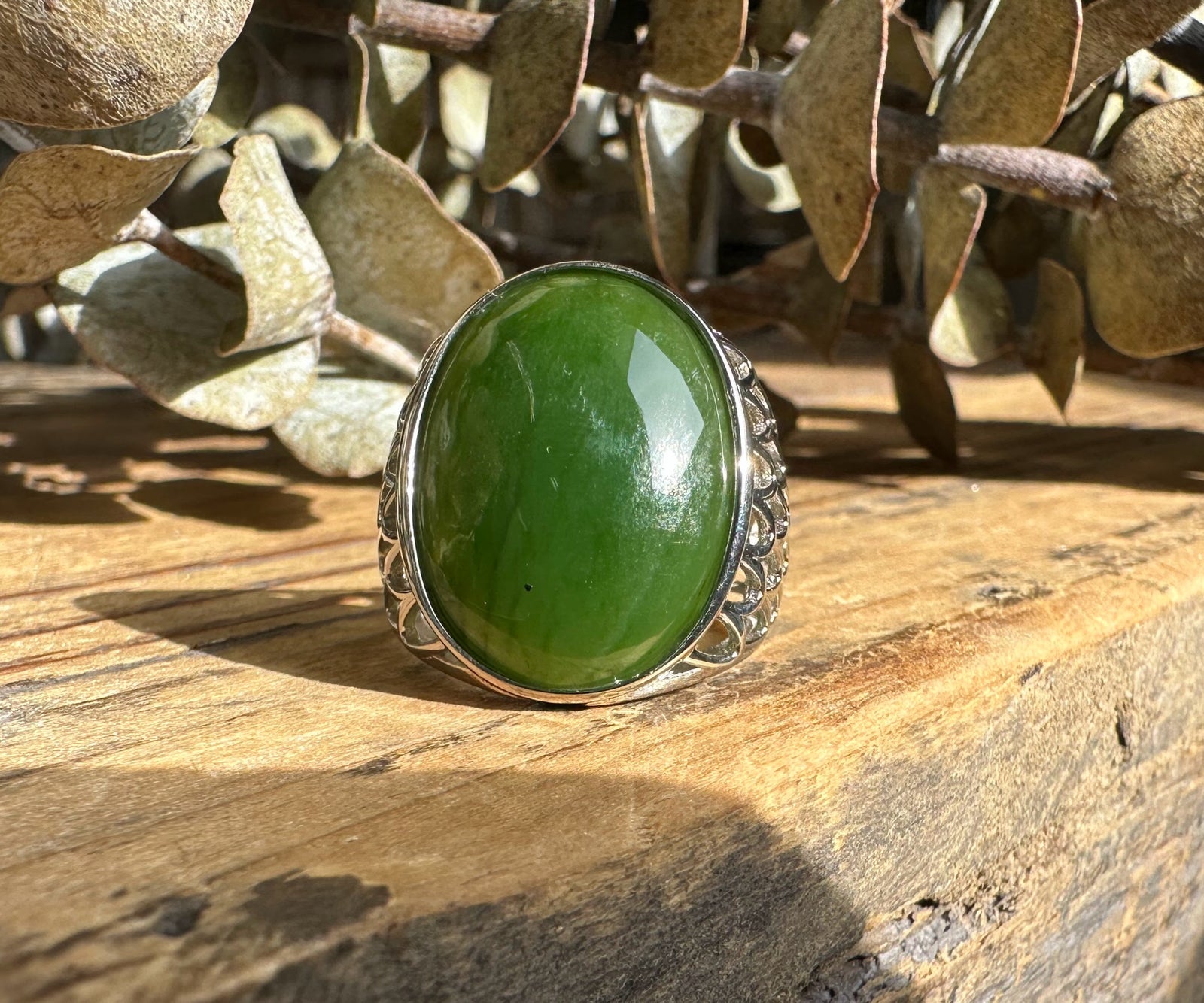 Canadian Jade Ring featuring a vivid green oval jade cabochon and an intricate lattice silver band