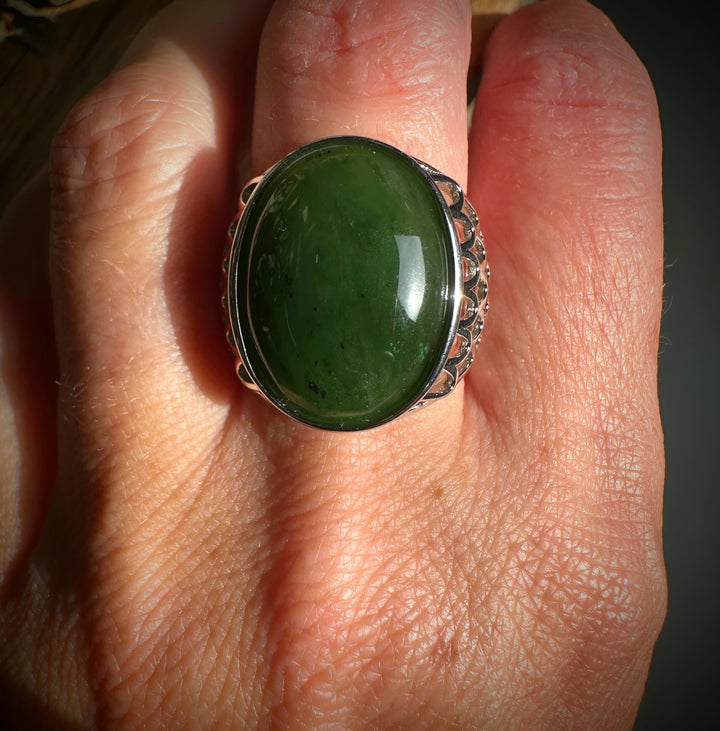Close-up of the Canadian Jade Ring worn on a finger, featuring a large green jade cabochon in a silver setting.