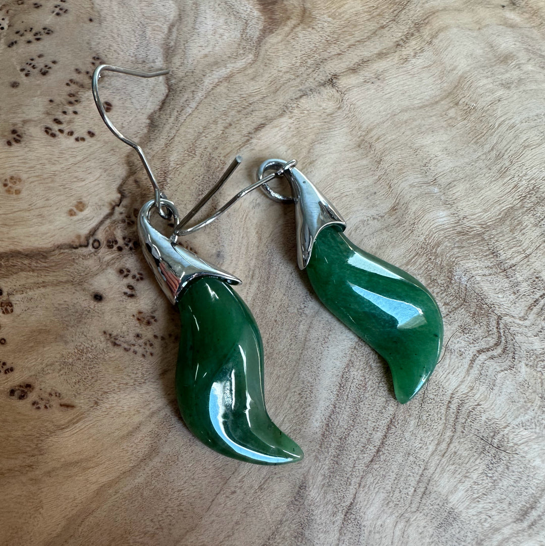 Two green nephrite jade drop earrings with curved leaf shapes and stainless steel hooks.