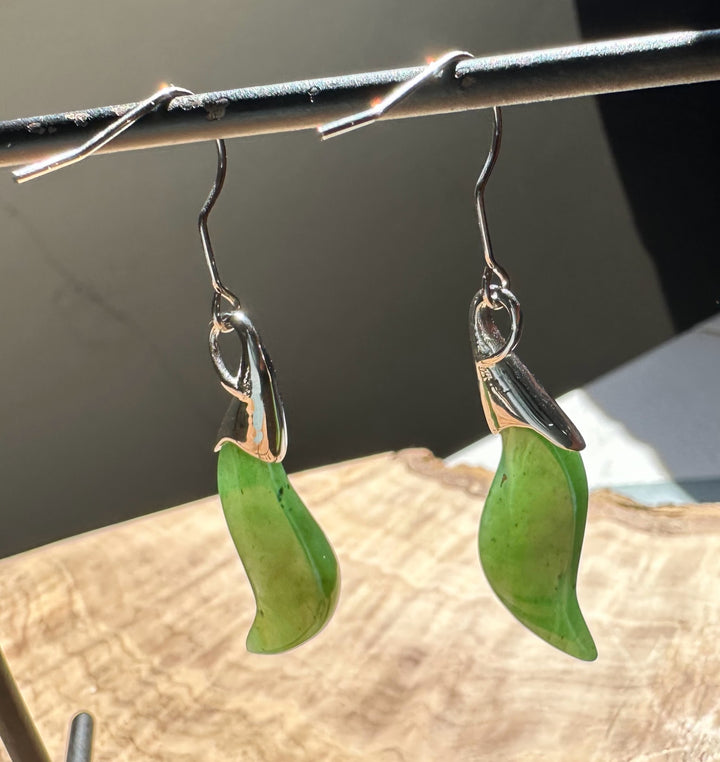 Green nephrite jade crescent earrings with polished silver caps and hook wires.