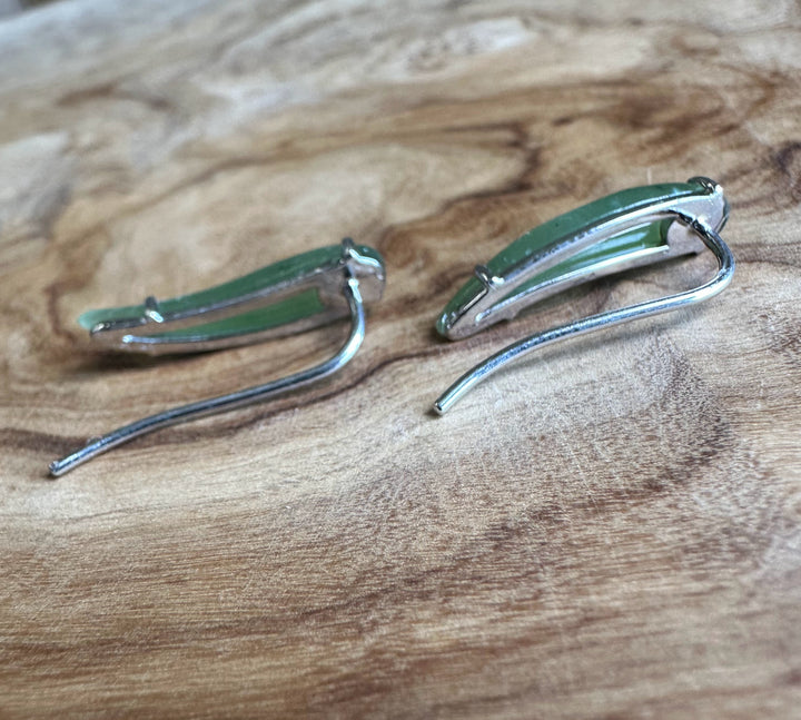 Pair of silver earrings on a wooden surface